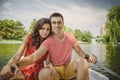 Young beautiful happy loving couple rowing a small boat on a lake. A fun date in nature. Couple in a boat. Royalty Free Stock Photo