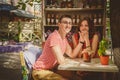 Young beautiful happy loving couple sitting at street open-air cafe holding hands. Beginning of love story. Relationship love Royalty Free Stock Photo