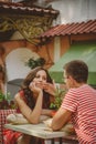 Young beautiful happy loving couple sitting at street open-air cafe looking at each other. Beginning of love story. Relationship Royalty Free Stock Photo