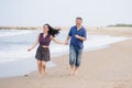 Young beautiful and happy mixed ethnicity couple of Asian woman and Caucasian man relaxed and cheerful running playful  on beach Royalty Free Stock Photo