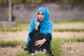 Young beautiful and happy muslim woman wearing islamic hijab head scarf and traditional clothing talking on mobile phone smiling c Royalty Free Stock Photo