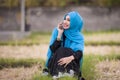 Young beautiful and happy muslim woman wearing islamic hijab head scarf and traditional clothing talking on mobile phone smiling c Royalty Free Stock Photo