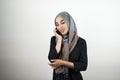Young beautiful happy Muslim woman wearing turban hijab headscarf talking on the smartphone isolated white background