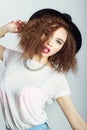 Young beautiful happy woman in a black hat, bright makeup, curly hair, fashion photography Studio on white background Royalty Free Stock Photo