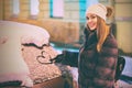 Young beautiful happy woman draws a heart shape symbol on the frozen car windscreen covered with snow Royalty Free Stock Photo