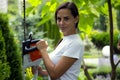 Young beautiful happy woman holding garden tool looking at camera. Royalty Free Stock Photo