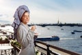 Young beautiful happy woman after a shower in a bathrobe and towel standing on the balcony with a cup of coffee. Cute sexy girl Royalty Free Stock Photo