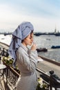 Young beautiful happy woman after a shower in a bathrobe and towel standing on the balcony with a cup of coffee. Cute sexy girl Royalty Free Stock Photo