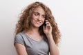 Young beautiful happy woman with smartphone in studio, making a phone call. Royalty Free Stock Photo