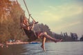 Young beautiful happy woman swinging on a swing on the beach during sunset, relaxing travel lifestyle concept Royalty Free Stock Photo