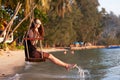 Young beautiful happy woman swinging on a swing on the beach during sunset, relaxing travel lifestyle concept Royalty Free Stock Photo