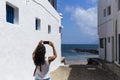 Young beautiful happy woman using her mobile phone over a white wall and sea background. Summer. Lifestyle Royalty Free Stock Photo