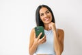 Young beautiful happy woman using smart phone. Excited surprised girl texting on her mobile phone isolated on grey background. Royalty Free Stock Photo