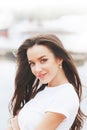 Young beautiful happy woman walks on beach in marina