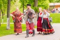 young beautiful harmonists walks with women in Russian national clothes on a city holiday in the park Royalty Free Stock Photo