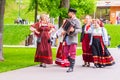 young beautiful harmonists walks with women in Russian national clothes on a city holiday in the park Royalty Free Stock Photo