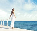 Young, beautiful and healthy girl on wooden pier at summer. Vacation, resort, traveling and tourism concept. Royalty Free Stock Photo