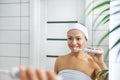 Young beautiful healthy woman brushes her teeth in front of a mirror in the bathroom Royalty Free Stock Photo