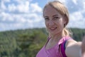 Young beautiful hiker woman taking selfie portrait on the top of mountain - Happy smiling girl using her smartphone - Royalty Free Stock Photo