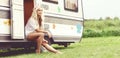 Young and beautiful hippy girl sitting on trailer at summer. Holiday, journey, vacation concept. Royalty Free Stock Photo