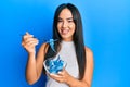 Young beautiful hispanic girl eating measure meter doing diet for weight loss smiling with a happy and cool smile on face Royalty Free Stock Photo