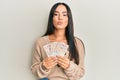 Young beautiful hispanic girl holding 10 united kingdom pounds banknotes looking at the camera blowing a kiss being lovely and