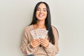 Young beautiful hispanic girl holding 10 united kingdom pounds banknotes smiling with a happy and cool smile on face