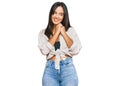 Young beautiful hispanic girl wearing casual clothes laughing nervous and excited with hands on chin looking to the side Royalty Free Stock Photo