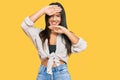 Young beautiful hispanic girl wearing casual clothes smiling cheerful playing peek a boo with hands showing face Royalty Free Stock Photo