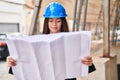 Young beautiful hispanic woman architect looking house plans at street Royalty Free Stock Photo