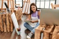 Young beautiful hispanic woman artist listening to music lying on floor at art studio Royalty Free Stock Photo