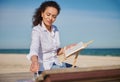 Young beautiful Hispanic woman artist painting in the open air on the beach Royalty Free Stock Photo