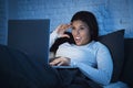 Young beautiful hispanic woman on bed at home laughing happy on laptop computer at night Royalty Free Stock Photo