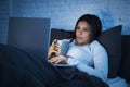 Young beautiful hispanic woman on bed at home working happy on laptop computer at night Royalty Free Stock Photo