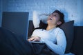 Young beautiful hispanic woman on bed at home working happy on laptop computer at night Royalty Free Stock Photo