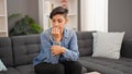 Young beautiful hispanic woman bitting nails stressed at home