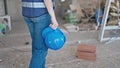 Young beautiful hispanic woman builder holding hardhat walking at construction site Royalty Free Stock Photo