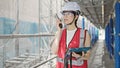 Young beautiful hispanic woman builder talking on walkie talkie using touchpad at street Royalty Free Stock Photo