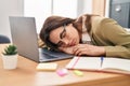 Young beautiful hispanic woman business worker leaning on laptop sleeping at office Royalty Free Stock Photo