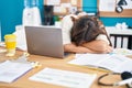 Young beautiful hispanic woman business worker leaning on table sleeping at office Royalty Free Stock Photo