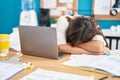 Young beautiful hispanic woman business worker leaning on table sleeping at office Royalty Free Stock Photo