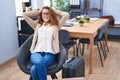 Young beautiful hispanic woman business worker relaxed waiting for travel at office