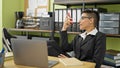 Young beautiful hispanic woman business worker sending voice message by smartphone relaxing with legs on table at office Royalty Free Stock Photo