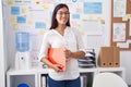 Young beautiful hispanic woman business worker smiling confident holding binder at office Royalty Free Stock Photo