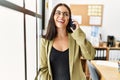 Young beautiful hispanic woman business worker smiling confident talking on smartphone at office Royalty Free Stock Photo