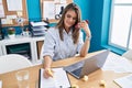 Young beautiful hispanic woman business worker talking on smartphone underlining document at office