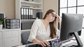 Young beautiful hispanic woman business worker tired using laptop working at office Royalty Free Stock Photo