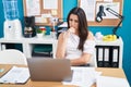 Young beautiful hispanic woman business worker using laptop with doubt expression at office Royalty Free Stock Photo