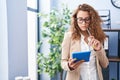 Young beautiful hispanic woman business worker using touchpad with serious expression at office Royalty Free Stock Photo