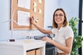 Young beautiful hispanic woman business worker writing on cork board at office Royalty Free Stock Photo